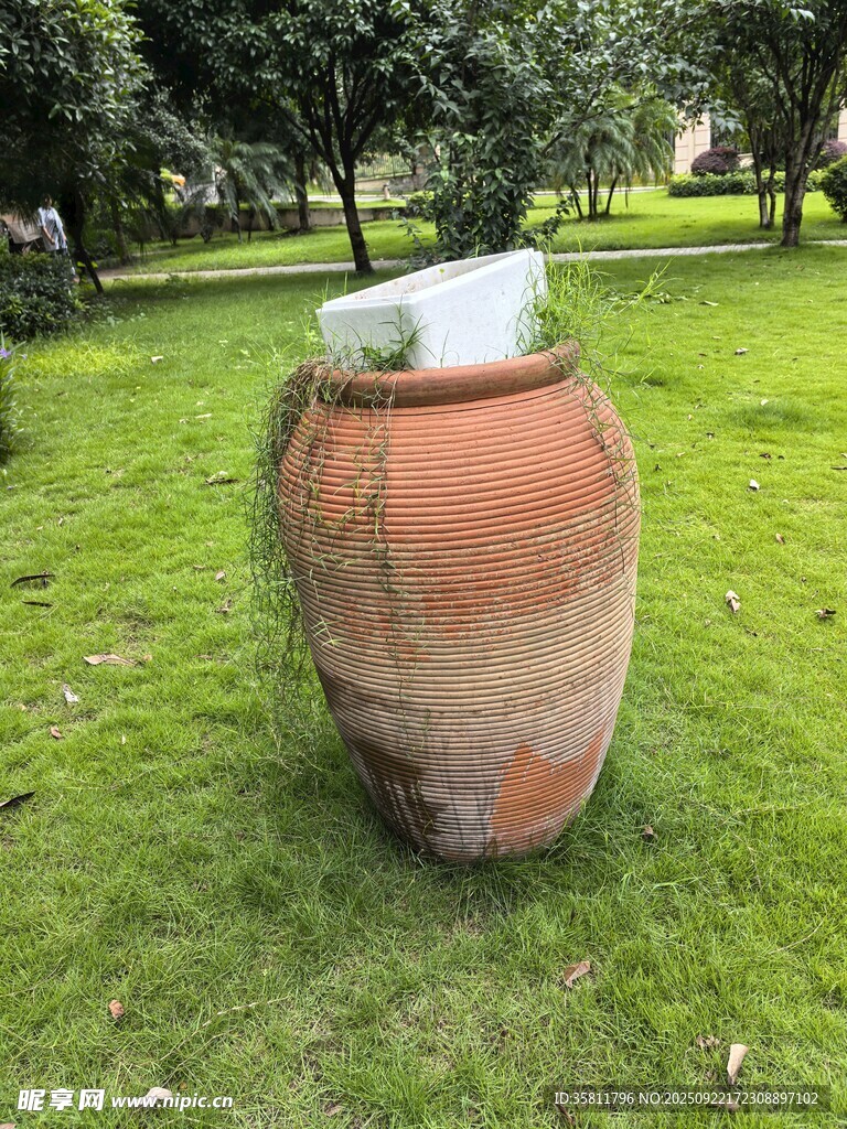 户外草地上的古朴大陶缸