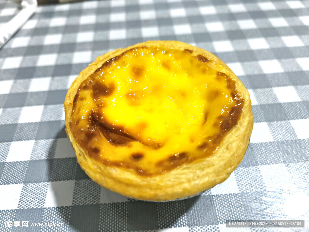 美味蛋挞置于格子桌布上
