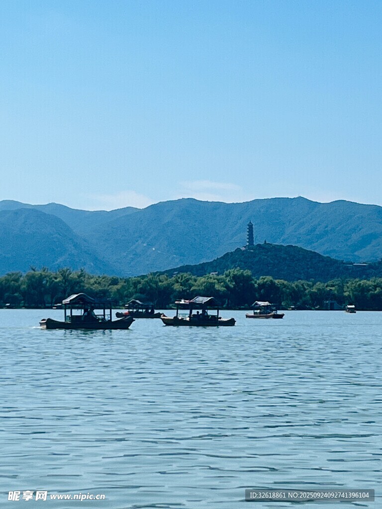 西湖碧波上的船只与远山