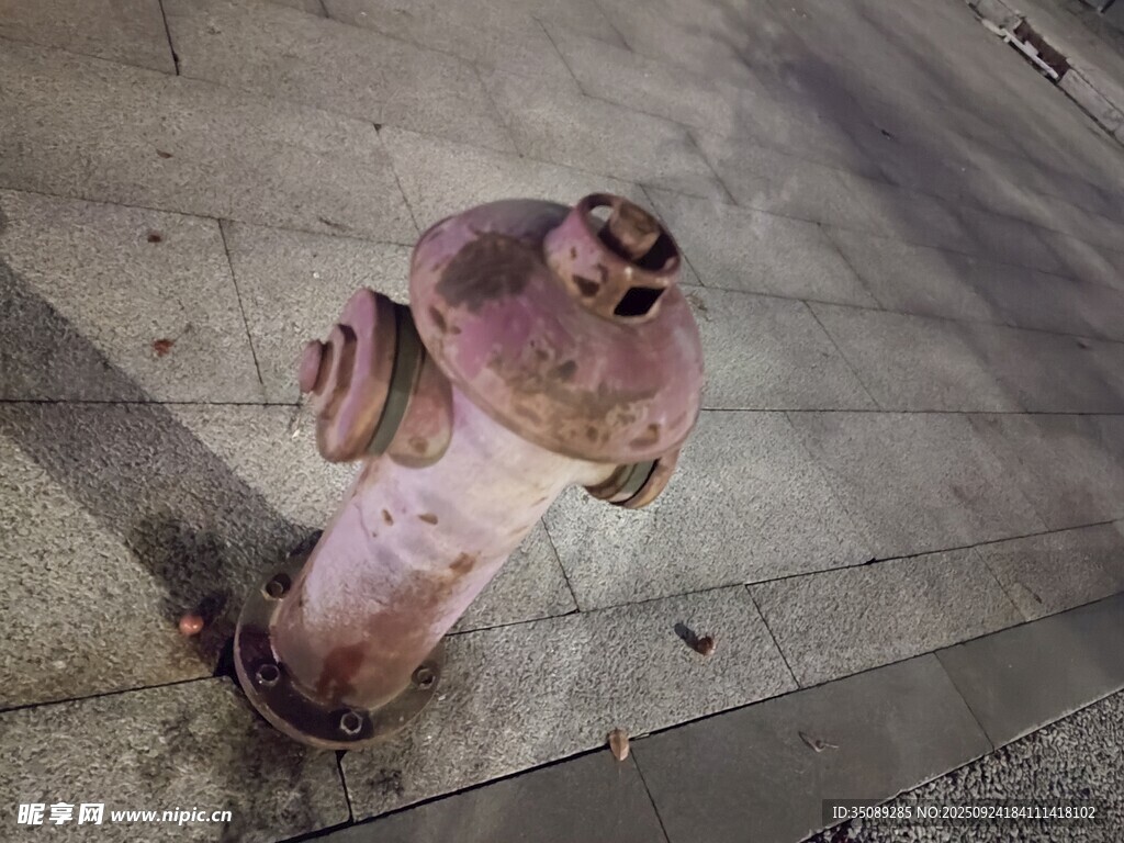 老旧粉色消防栓置于地面