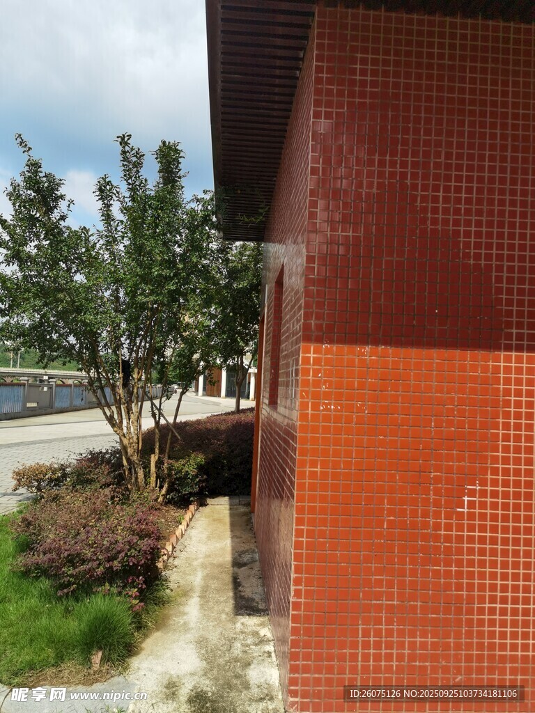 红砖建筑旁的绿植与小径
