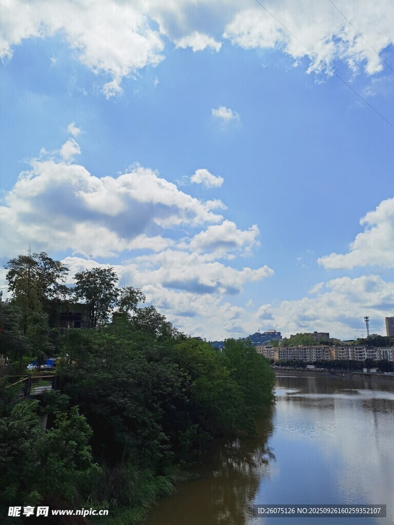 河畔蓝天绿树风景图