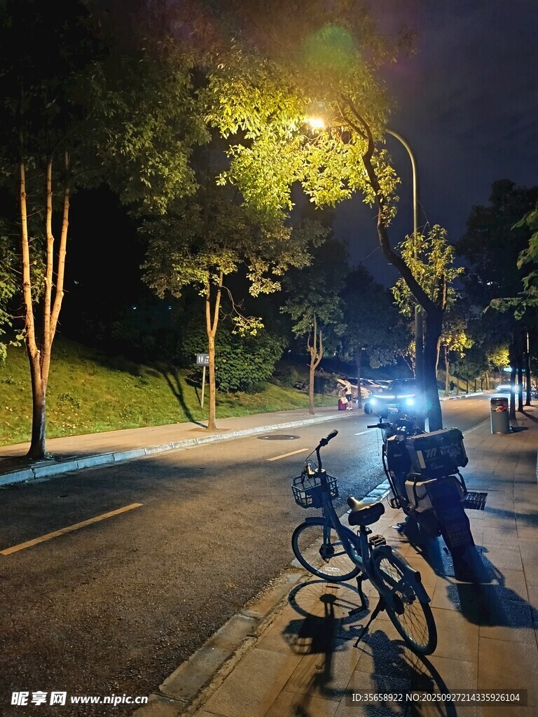 夜晚路边停放的自行车与行人