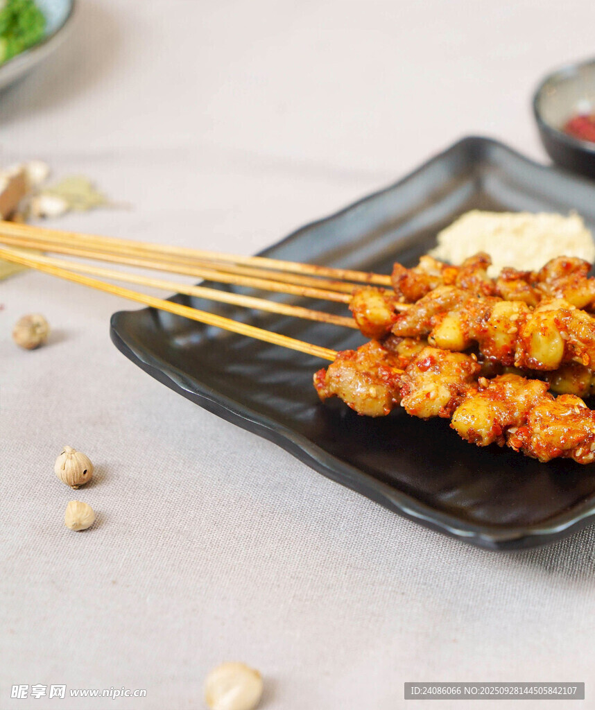 美味烤肉串置于黑色盘上