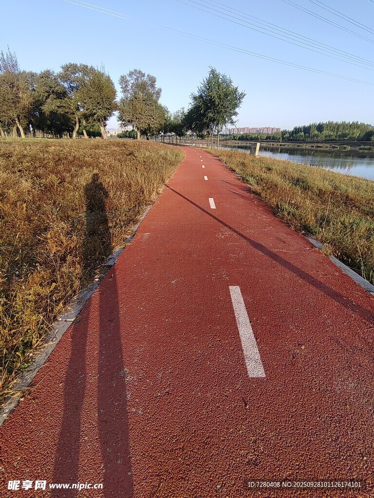 秋日河畔的红色骑行步道