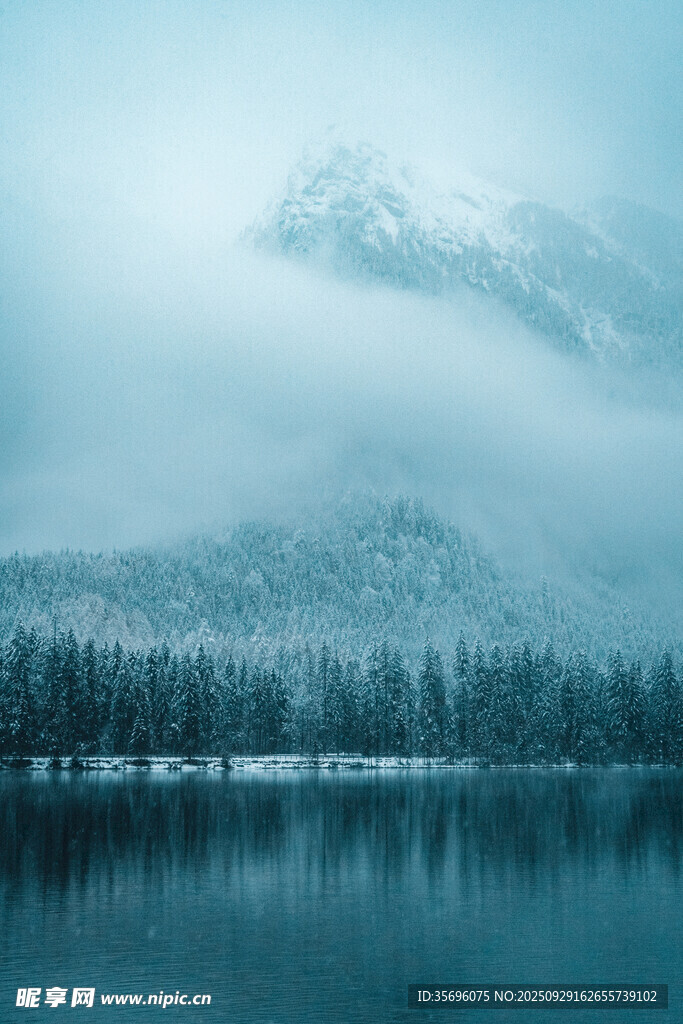 雾霭笼罩的静谧雪山湖泊