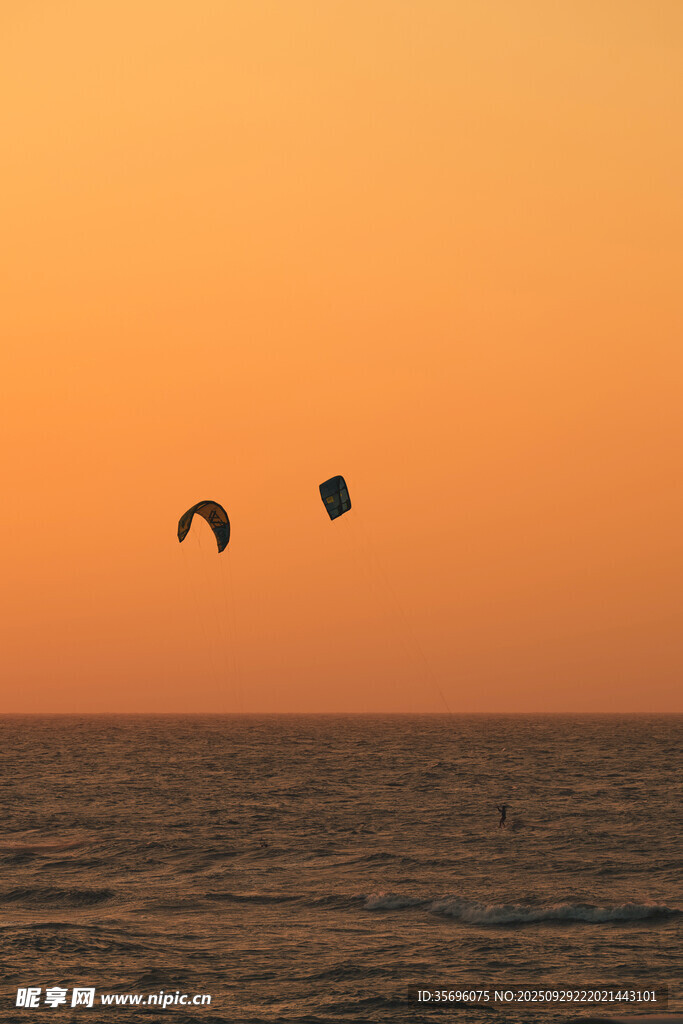 海上夕阳下的双滑翔伞