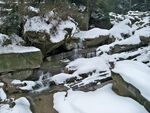 雪覆山石间的潺潺溪流