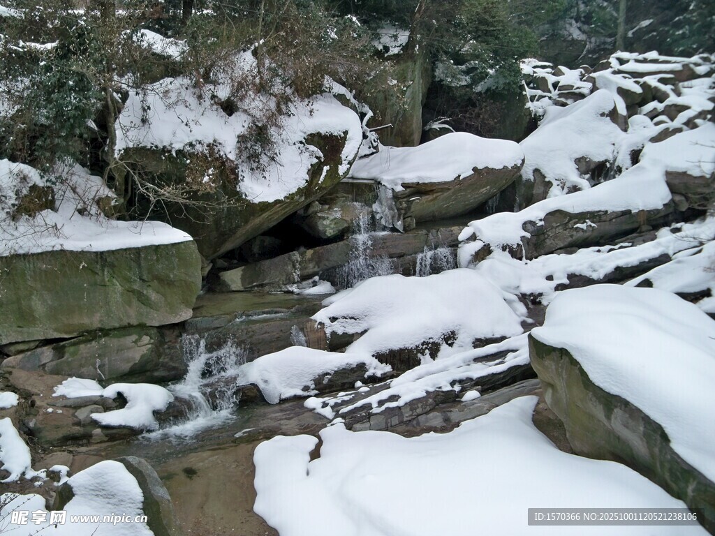 雪覆山石间的潺潺溪流