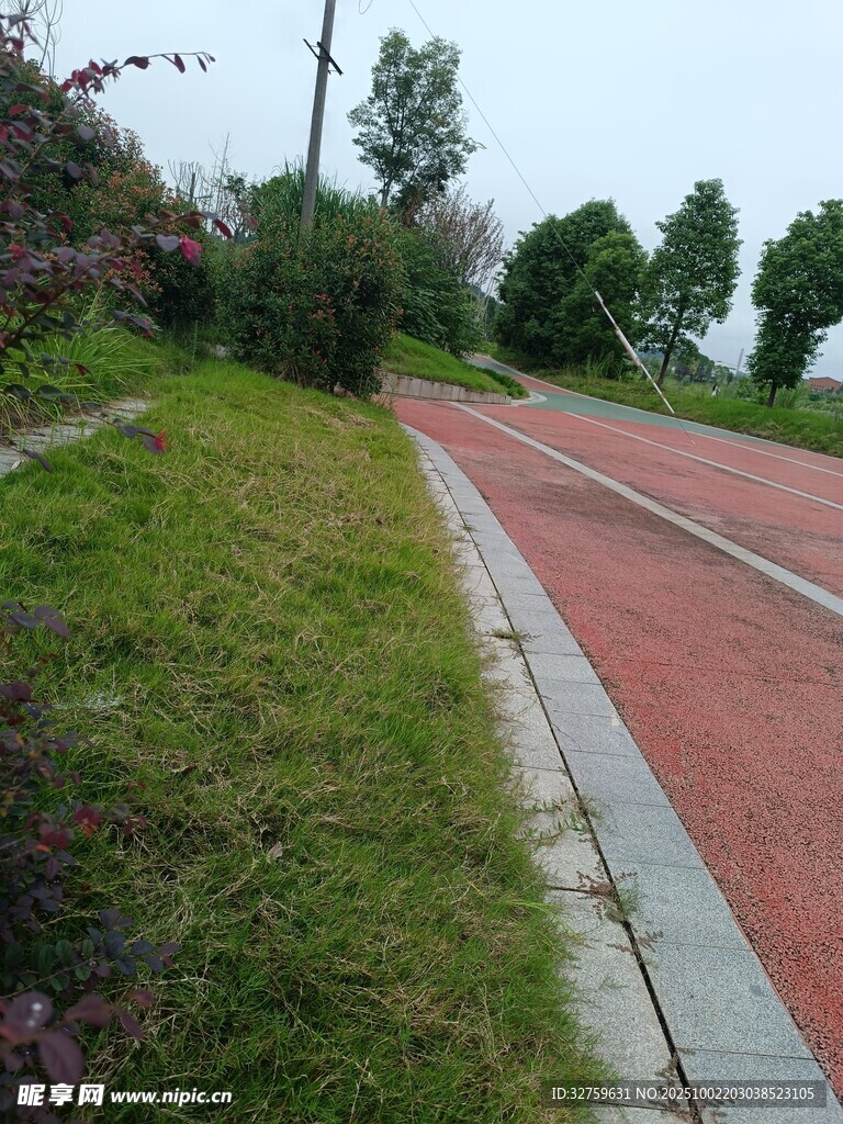 户外红色步道旁的绿地