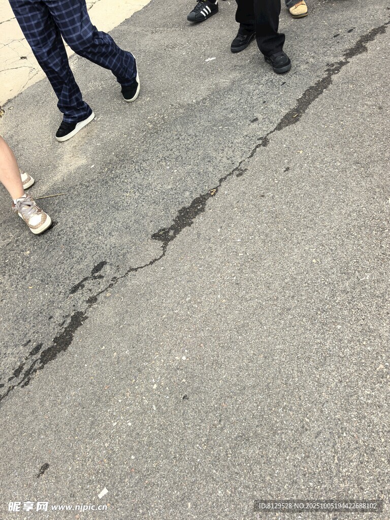 行人走在有裂缝的路面