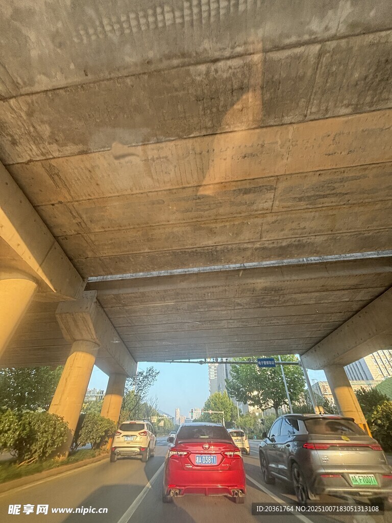 桥下公路上行驶的红色汽车