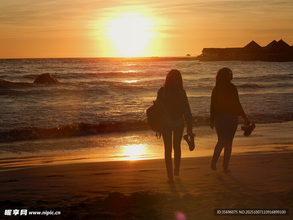 夕阳下海滩漫步的两人