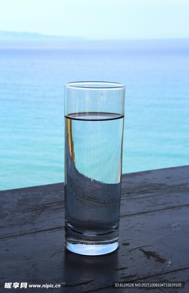 海边木桌上的透明水杯