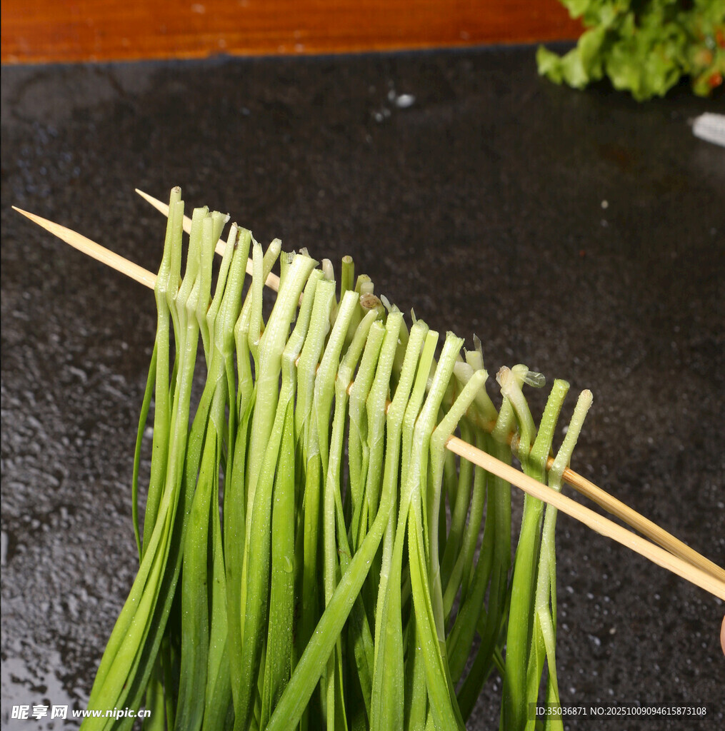 新鲜韭菜串在竹签上