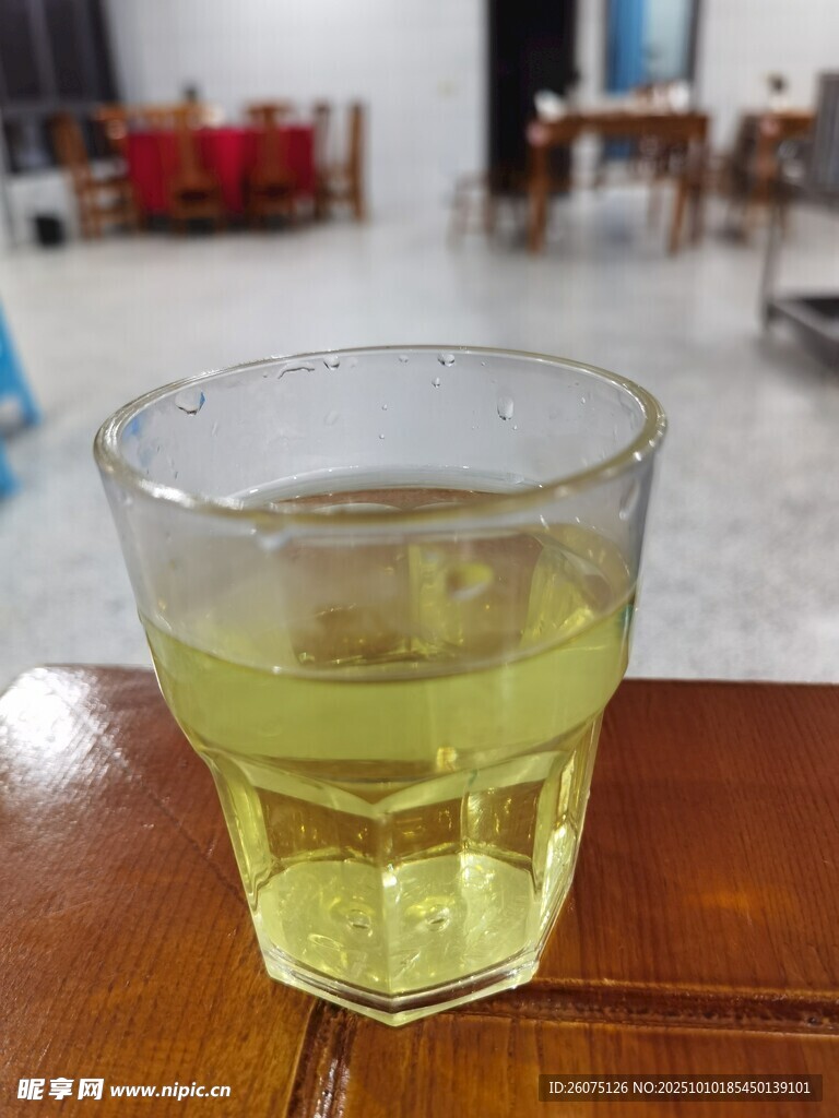 木桌上的一杯黄绿色饮品