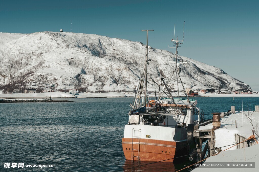 雪覆山峦旁的停靠船只