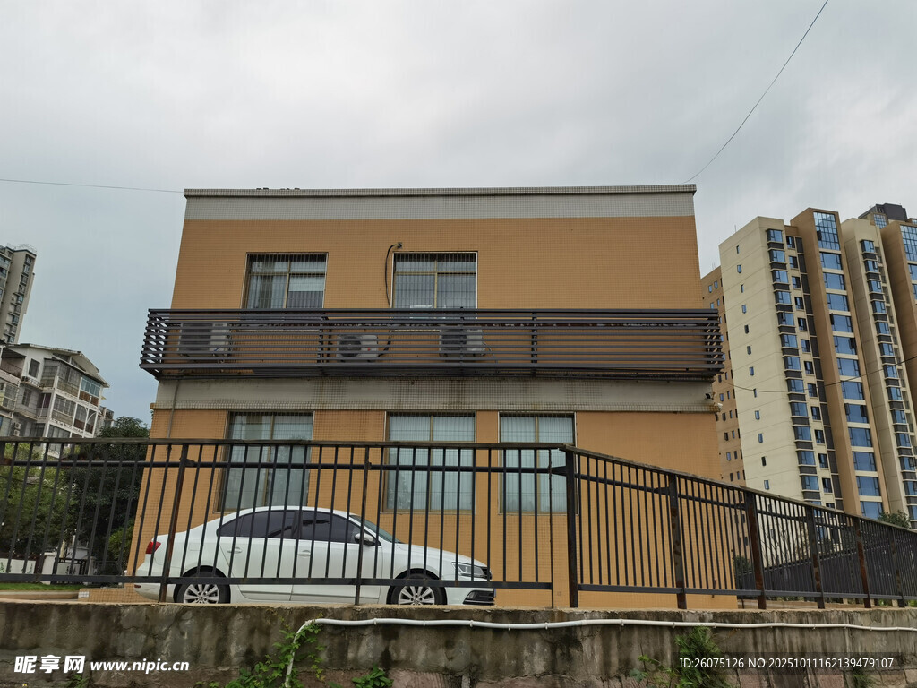 黄墙建筑旁停着白色轿车