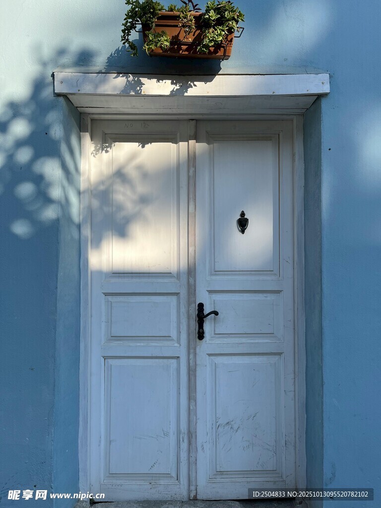蓝墙白门顶置盆栽景致