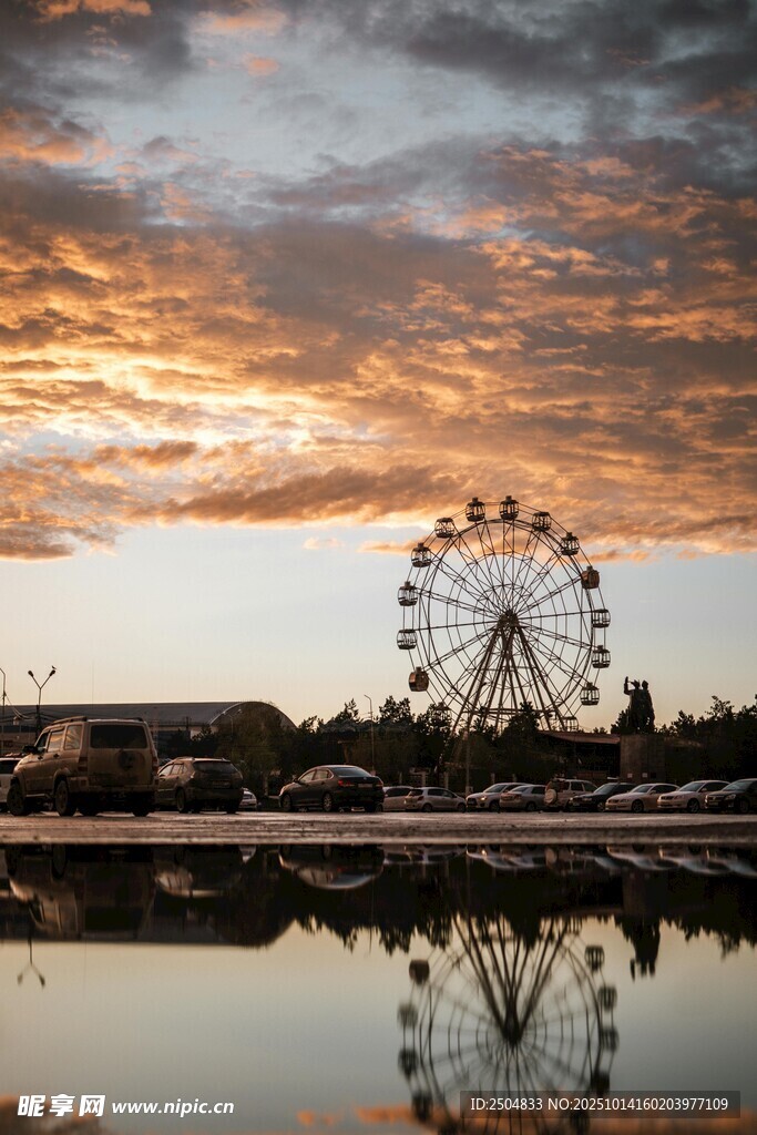 夕阳下的摩天轮与湖面倒影