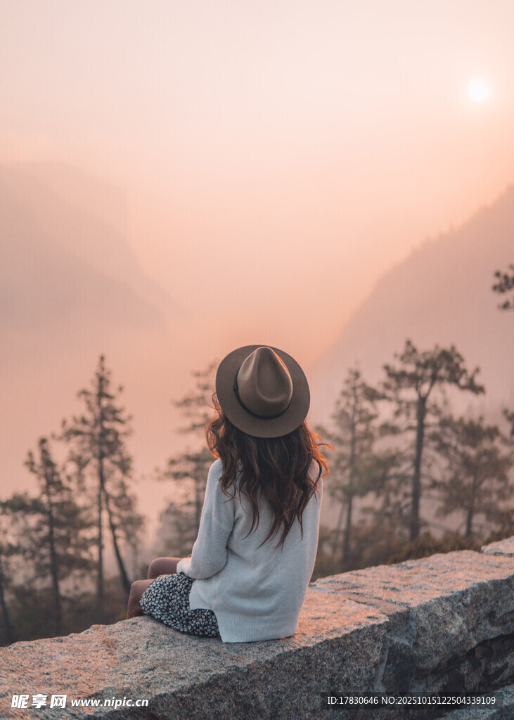 女孩独坐赏山间日落美景