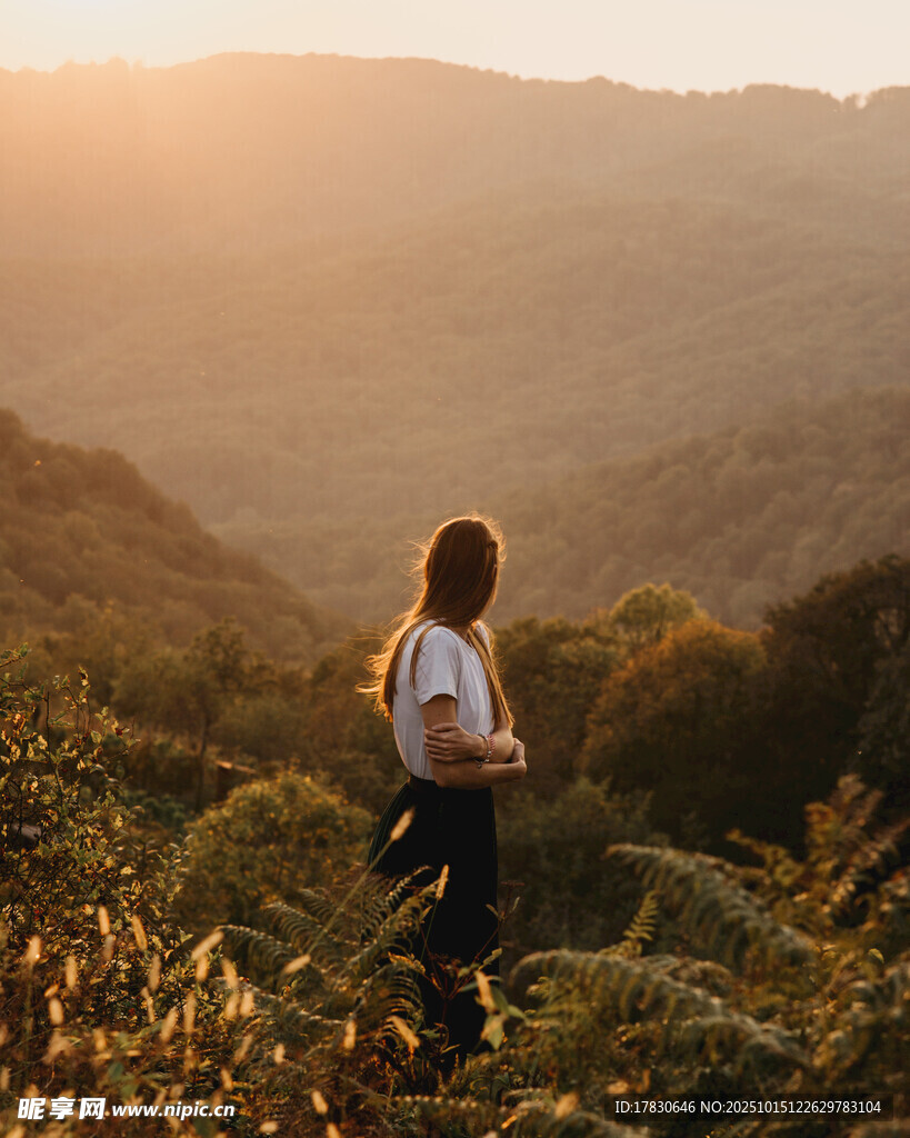 女子于山间逆光而立赏景