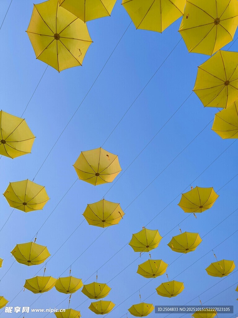 蓝天中悬挂的黄色雨伞