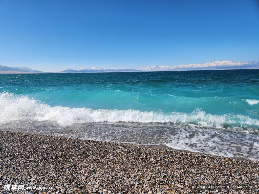 蓝天下的砾石海滩海浪