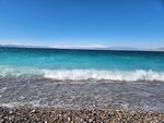 蓝天下的砾石海滩与海浪