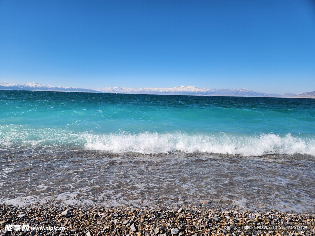 蓝天下的砾石海滩与海浪