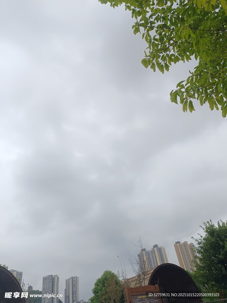 城市上空的阴云与绿树