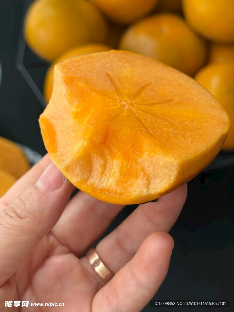 手捧切开的金黄甜柿子