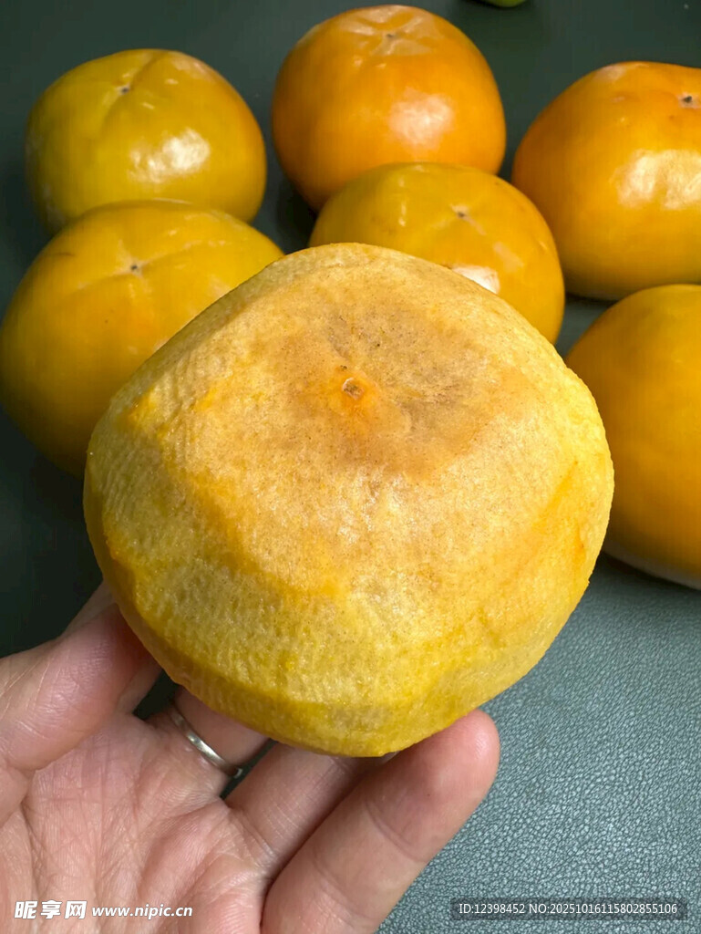 手捧黄澄澄的新鲜柿子