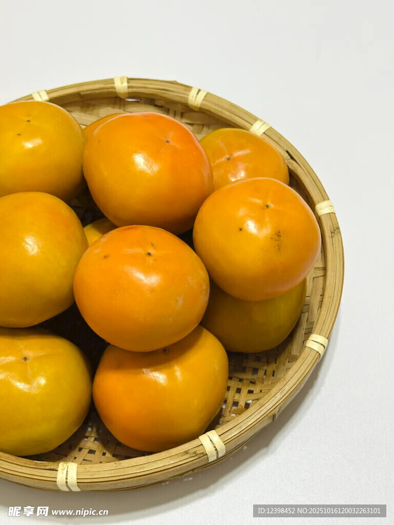 竹篮中的圆润橙黄柿子