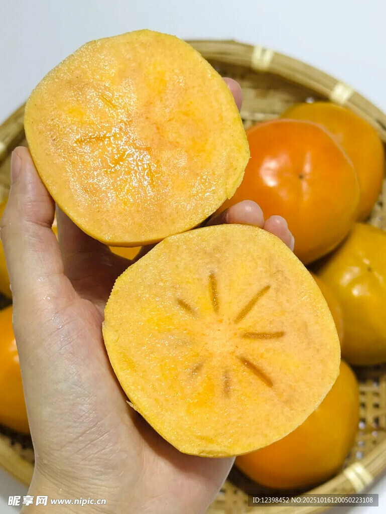 手捧切开的新鲜甜柿子