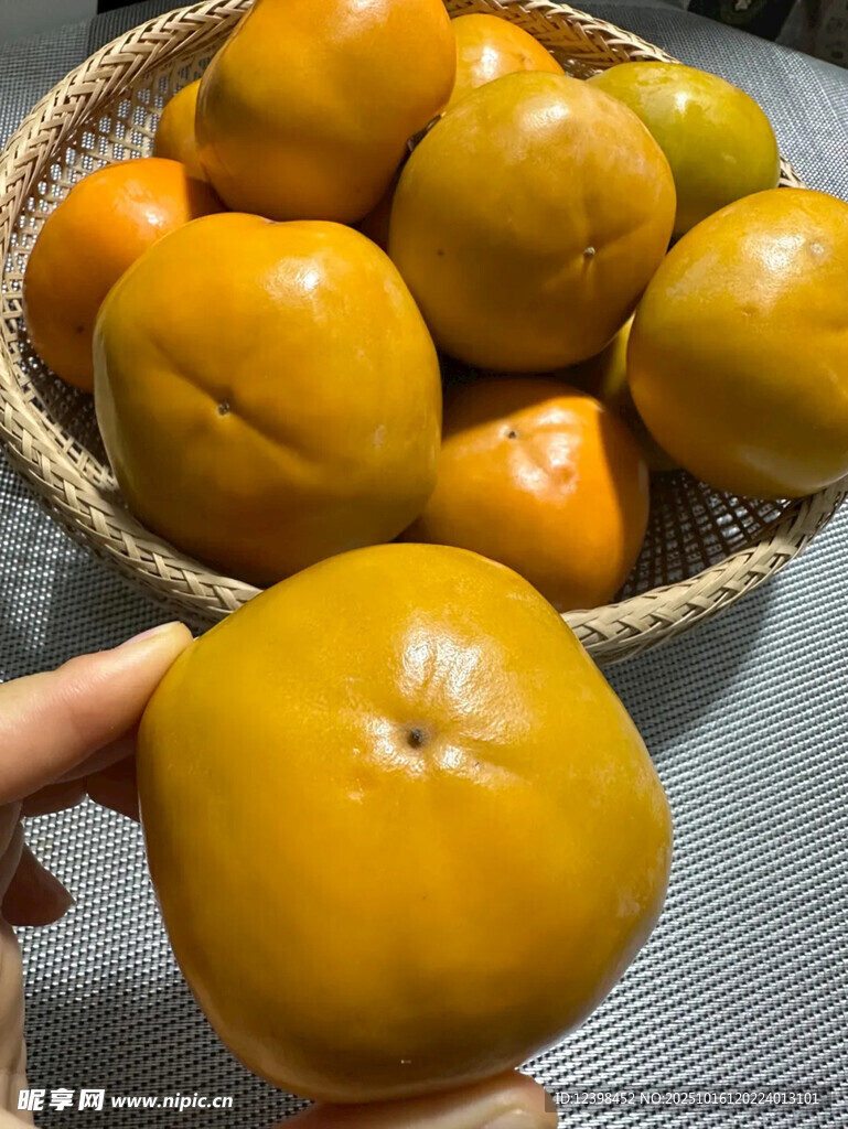 手捧金黄柿子与果篮