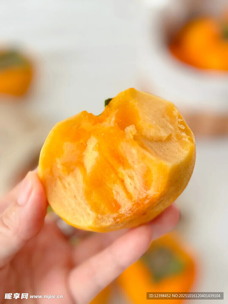 手捧剥开的橙黄色甜柿子