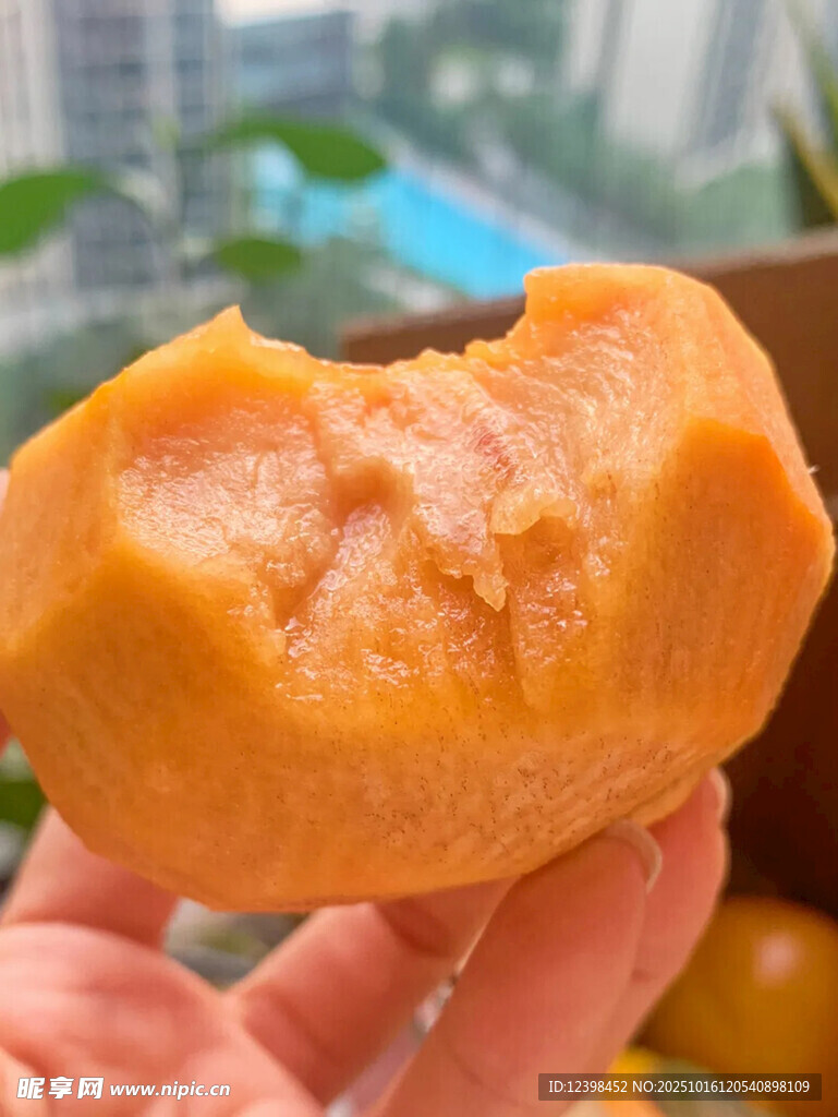 手捧咬过的甜软黄柿子