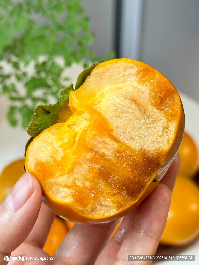 手捧多汁黄澄澄的甜柿子