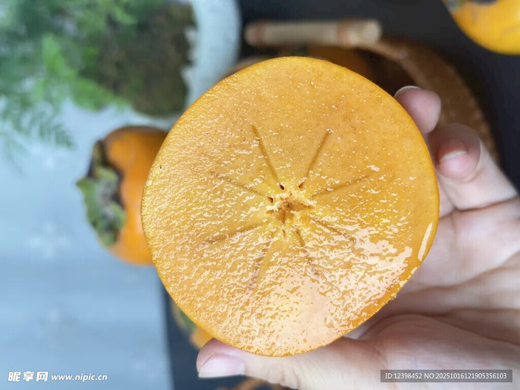 手捧切开的新鲜黄柿子