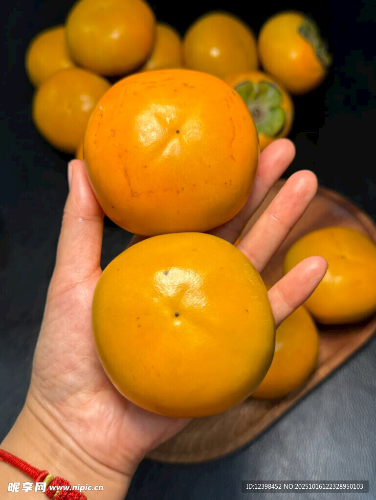 手捧新鲜饱满的黄柿子