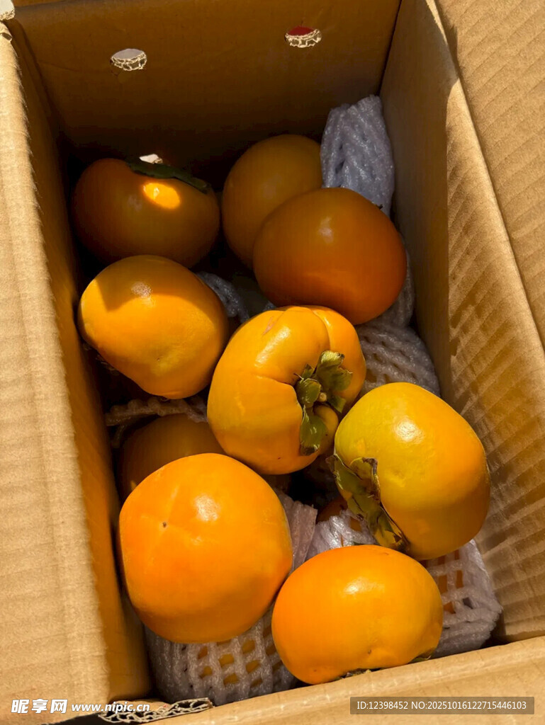 纸箱中的新鲜橙黄色柿子