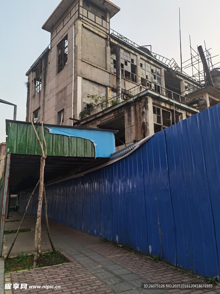 蓝色围挡旁的老旧建筑