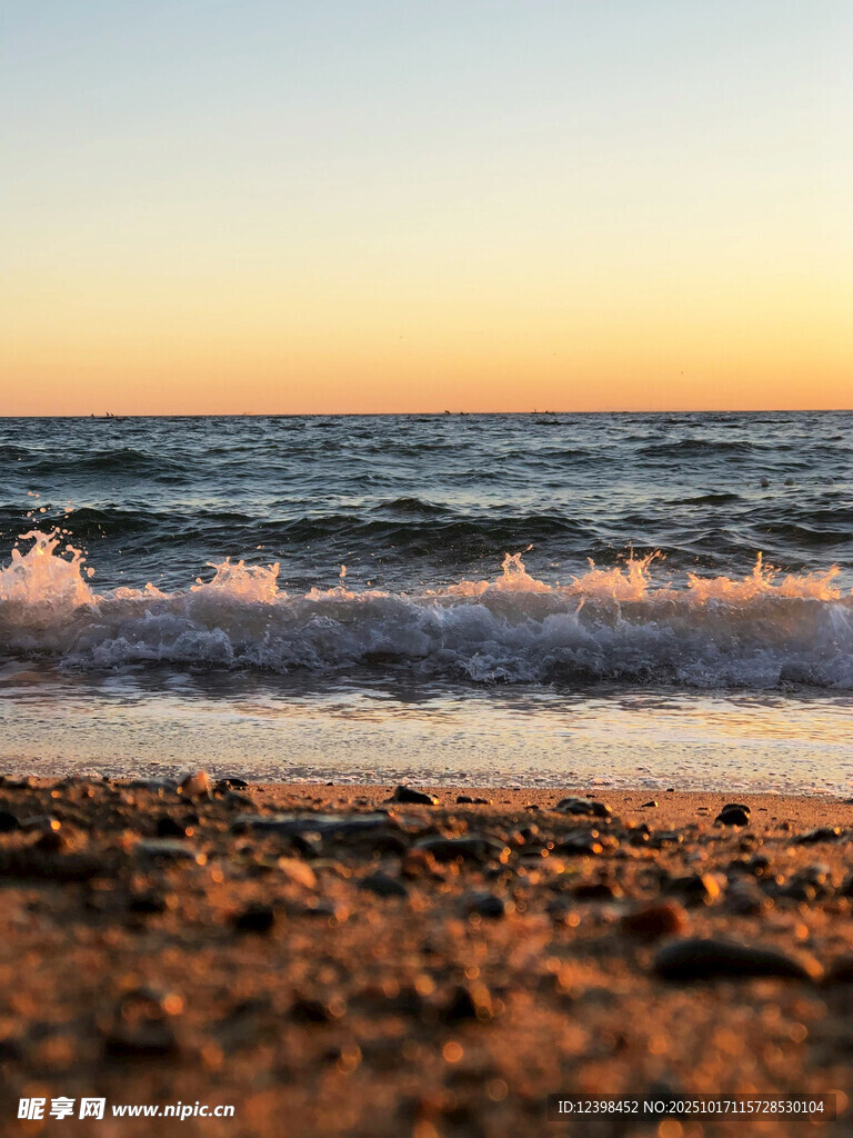 夕阳下的海浪拍打沙滩