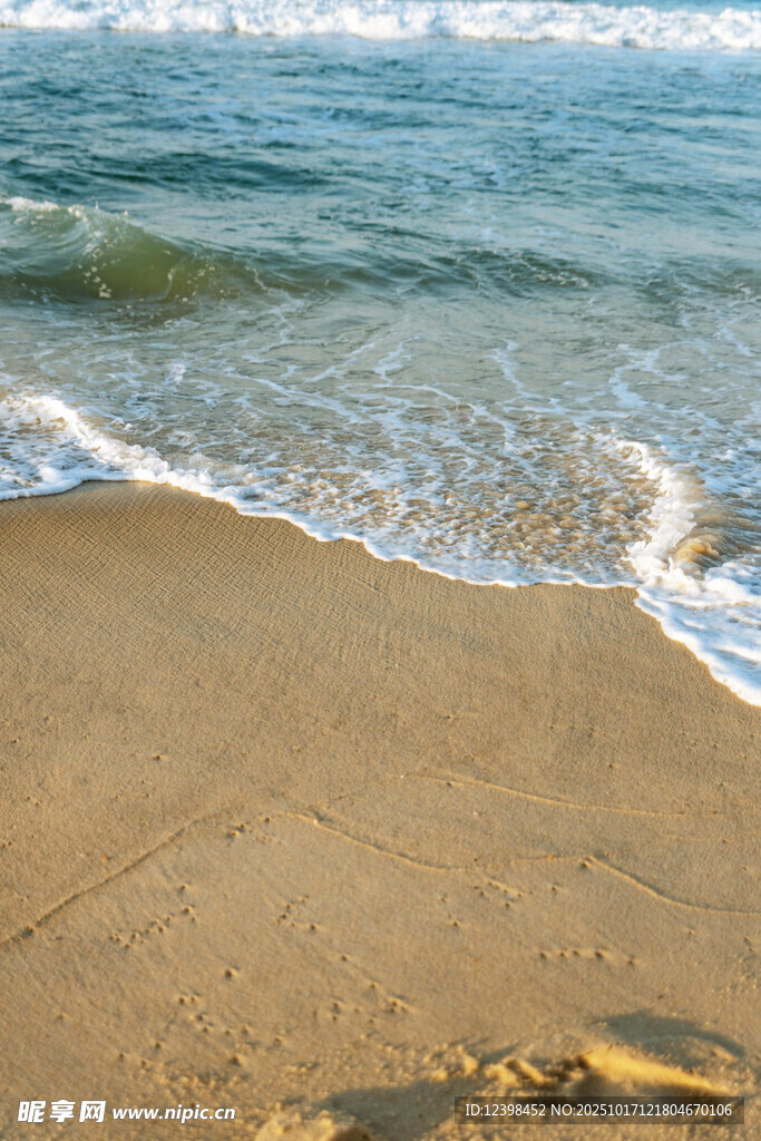 海边沙滩上的海浪与脚印