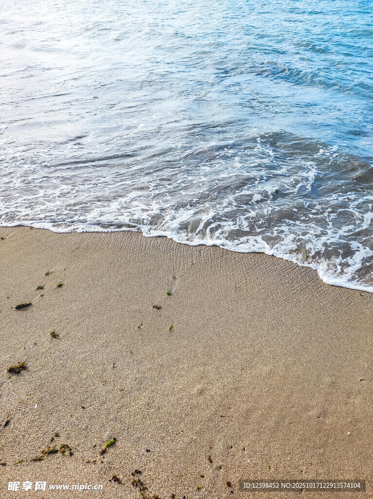 海边沙滩上的海浪与脚印