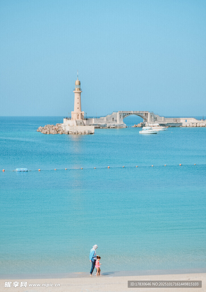 海边灯塔下的漫步情侣