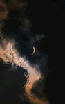 夜空中的新月与缥缈云彩