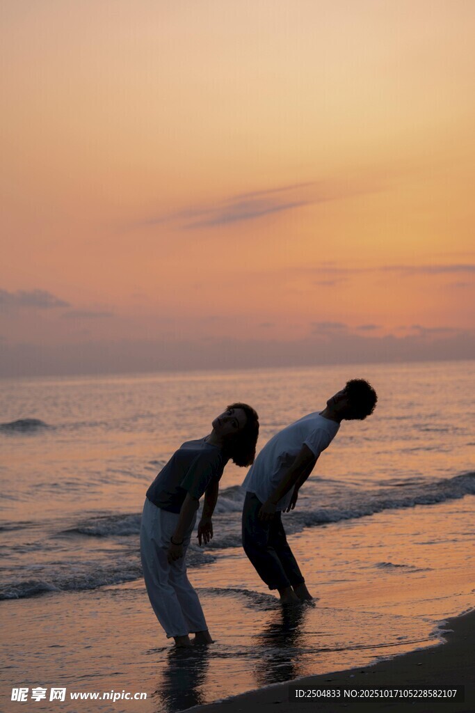 夕阳下海边的亲密情侣