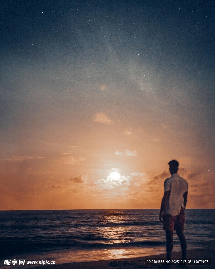 夕阳下海边独自站立的人